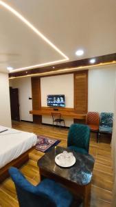 a hotel room with a bed and a table and chairs at Hotel Gandharva Executive in Pune