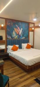 a bedroom with a large bed with a painting on the wall at Hotel Gandharva Executive in Pune