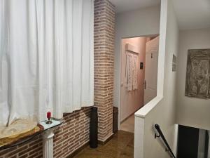 a hallway with a brick wall and a window at Casa de la Plata in Colmenar de Oreja