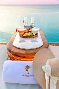 a tray with two drinks and a hat on a table at Le Saint Tropez in Kidoti