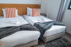 two beds with blankets and pillows in a room at Apartment II Estrela da Calheta in Calheta