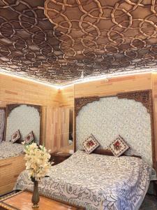 a bedroom with two beds and a wooden ceiling at Cheetah Palace in Srinagar