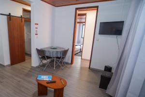 a living room with a table and a tv in a room at Apartment II Estrela da Calheta in Calheta