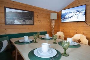 a dining room with a table with a tv on the wall at Astlhof in Grossarl