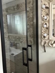 a glass shower door with a mirror on a wall at Villa Dimarts- a 100m de playa in Gandía +30 photos