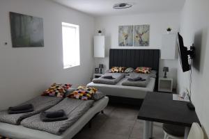 a bedroom with two beds and a table at Apartmán HARMONY - Lipno nad Vltavou in Lipno nad Vltavou