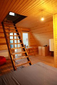 a wooden staircase in a room with a bed at Black Castle Red Valley in Sevaberd