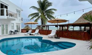 a swimming pool with chairs and umbrellas on a patio at Mata Rocks Resort in San Pedro