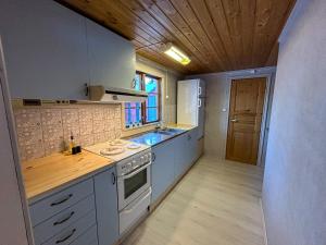 eine Küche mit weißen Geräten und einer Holzdecke in der Unterkunft Farmstay Götes Cabin, 2p in Årjäng