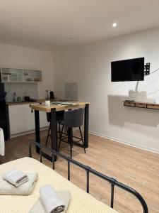 a room with a table and a tv on the wall at Studio moderne tout confort in Vierzon
