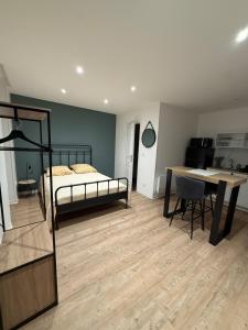 a bedroom with a bed and a desk and a table at Studio moderne tout confort in Vierzon