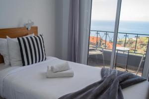 ein Schlafzimmer mit einem Bett und Meerblick in der Unterkunft Sunset Star with Sea View in Calheta