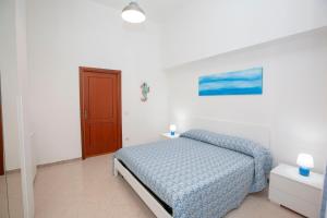a bedroom with a bed with a blue blanket at Amalfi mia - city center in Amalfi