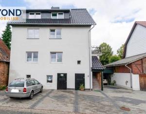a white house with a car parked in front of it at FeWo ,Sonnenschein ,Sollstedt in Sollstedt
