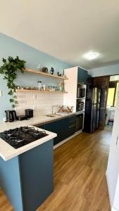 a kitchen with a stove and a counter top at Segurança e conforto na Praia Brava a 100 do mar - Condomínio Curimã in Florianópolis