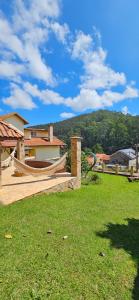 a yard with a hammock and a house at Pousada Winterhaus in Monte Verde