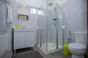 ein weißes Badezimmer mit Dusche und Toilette in der Unterkunft Sunset Star with Sea View in Calheta + 80 Fotos