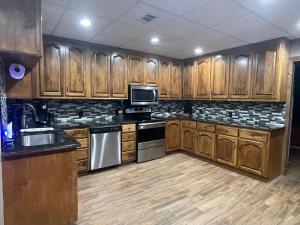 a kitchen with wooden cabinets and stainless steel appliances at Lake Oconee Waterfront Apartment in Greensboro