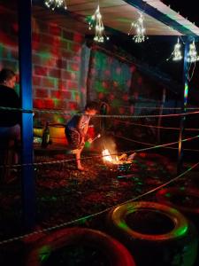 a little boy standing around a fire in a room at Hostal mil colores in Guacamayas