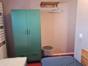 a bedroom with a green cabinet and a stool at Die große Wohnung in Droyßig