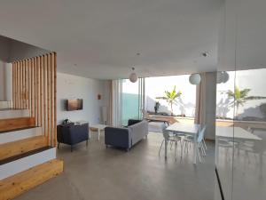 a living room with a couch and a table and chairs at CORRALEJO SURF HOUSE & SCHOOL only SURF in Corralejo