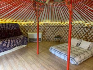 a bedroom in a yurt with a bed and a couch at Yurta cerca de Madrid in Madrid +5 photos