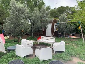 a backyard with white chairs and a fire pit at Yurta cerca de Madrid in Madrid
