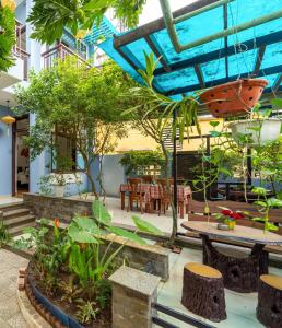 a courtyard with tables and chairs and trees at Smart Garden Homestay in Hoi An