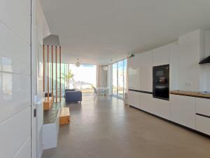 a kitchen with white cabinets and a living room at CORRALEJO SURF HOUSE & SCHOOL only SURF in Corralejo