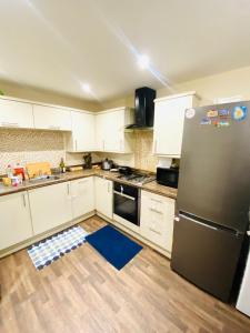 a kitchen with white cabinets and a black refrigerator at Stay with H&S in Kirk Sandall