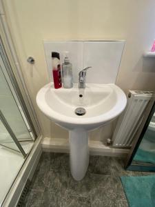 a white sink in a bathroom next to a shower at Stay with H&S in Kirk Sandall