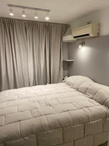 a bedroom with a large white bed in front of a window at Verde Laurel in Concepción del Uruguay