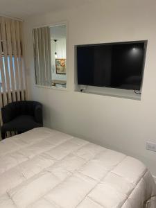a bedroom with a bed and a flat screen tv at Verde Laurel in Concepción del Uruguay