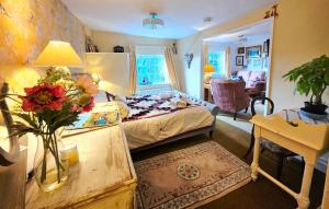 a bedroom with a bed and a table with flowers on it at The Annexe Lurley Manor in Tiverton