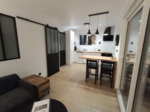 a living room and kitchen with a table and a couch at Chez Mat's & Lou in Rocheville