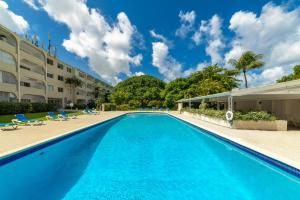 a swimming pool at a resort with blue water at Golden Gem Cosy Apartment with pool & garden view in Saint James
