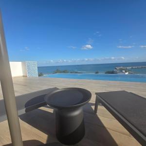 a table and bench on a balcony with a view of the ocean at MIRAMARE Ocean View in Puerto Morelos