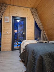 a bedroom with a bed in a room with a window at Escape Remeti - Aframe by the River in Remeţi +55 photos
