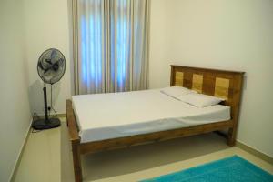 a bedroom with a bed with a fan and a window at Cinnamon River Retreat in Magammana