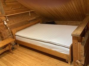 a small bed in a room with a wooden floor at Northern lights home opposite the mountains in Ylikyro +46 photos