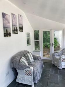 a living room with a couch and some pictures on the wall at The Eliot Cottage in South Petherwin