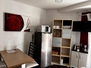a kitchen with a refrigerator and a table and a microwave at Mello's House in Curitiba