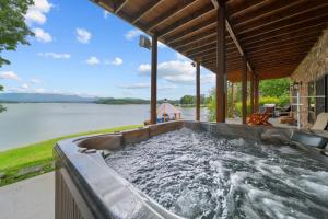 an outdoor hot tub with a view of the water at Cozy Cabin Style Lake House w Theatre Room & Dock in Sevierville