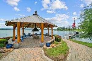 a gazebo on a brick path next to a lake at Cozy Cabin Style Lake House w Theatre Room & Dock in Sevierville