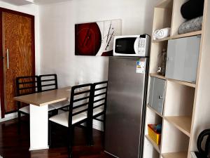 a kitchen with a table and a refrigerator and a microwave at Mello's House in Curitiba +59 photos