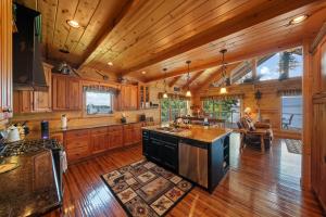 a large kitchen with wooden walls and wooden flooring at Cozy Cabin Style Lake House w Theatre Room & Dock in Sevierville +82 photos