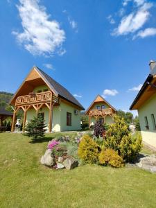 a house with a deck on the side of a yard at Domki pod Derkaczem in Radków