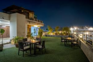 a patio with tables and chairs on the roof at night at Hotel Neu Villa, City Centre - Near Connaught Place & NDLS Station in New Delhi