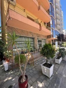 a group of potted plants in front of a building at Hotel Edland in Vlorë