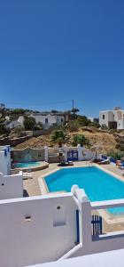 a swimming pool on the side of a villa at Rita's Place Hotel in Ios Chora